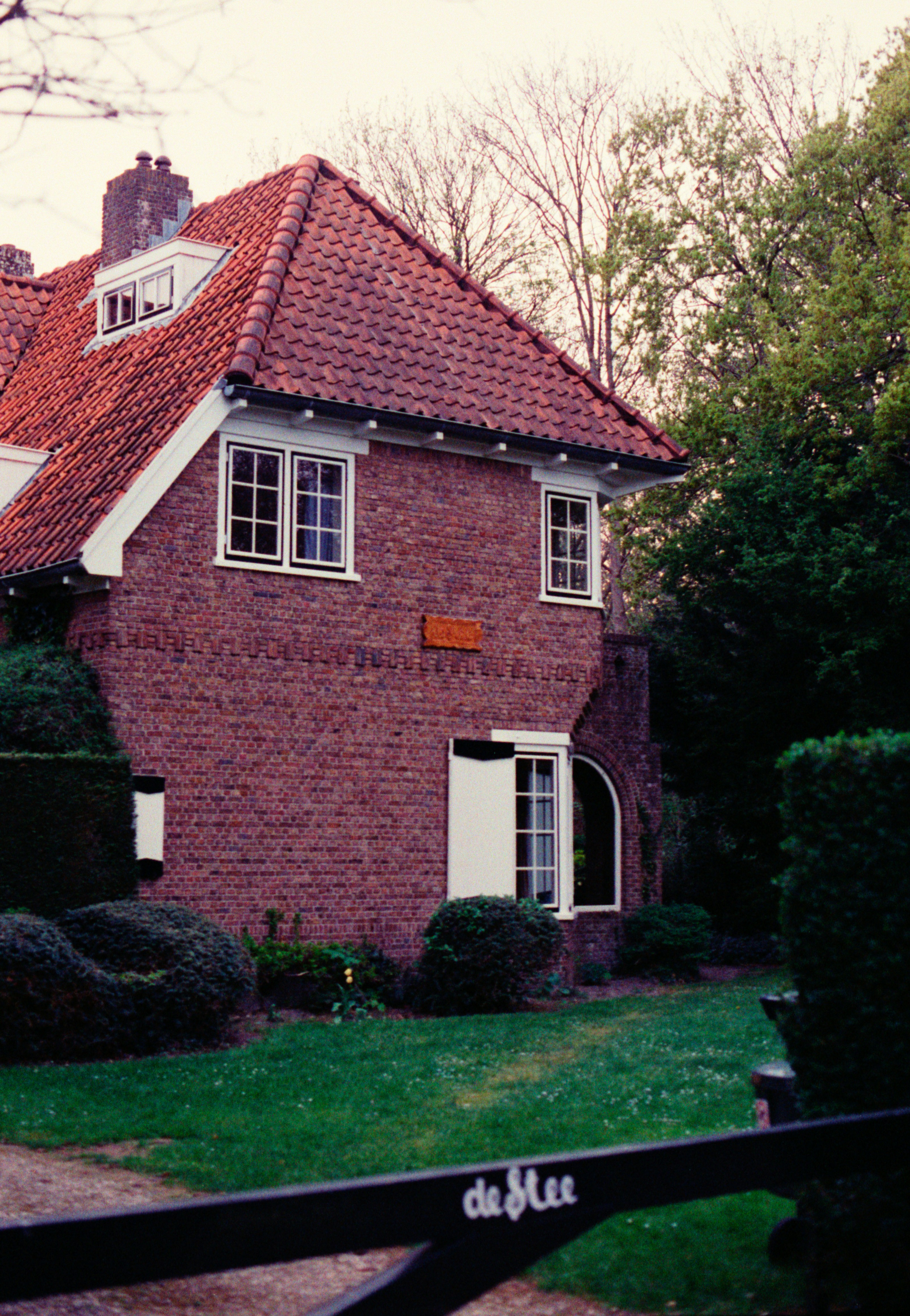 A brick house with red tile roof.